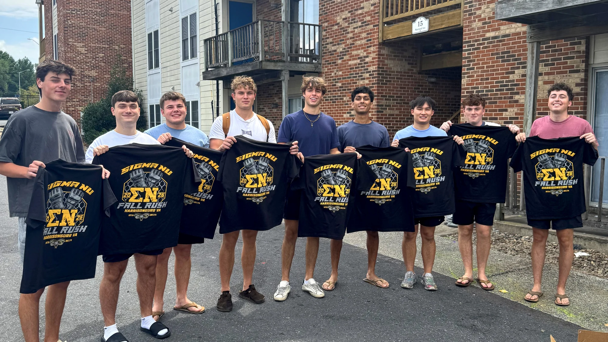 Fraternity members holding their Sigma Nu fall rush shirts