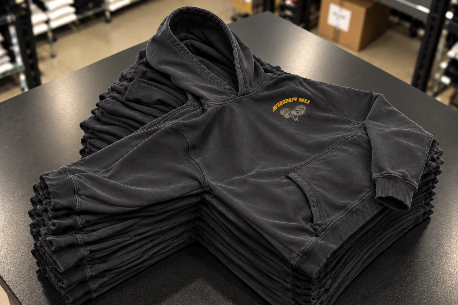 A stack of folded custom hoodies on a table